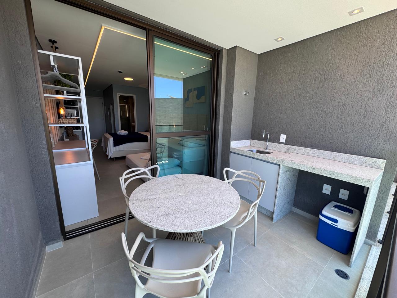 Flat na praia — varanda gourmet com bancada em granito e mesa